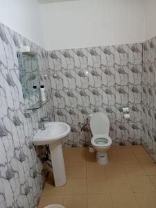 a bathroom with a toilet and a sink at Jolie Résidence de 03 chambres salon Légbassito in Atyémé +8 photos