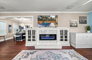 een woonkamer met open haard en tv bij Step into the charm of yesteryear with the modern comforts of today at City Cottage! in Sarasota