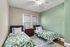 een slaapkamer met twee bedden en een plafondventilator bij Step into the charm of yesteryear with the modern comforts of today at City Cottage! in Sarasota +59 foto's