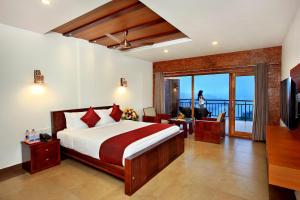 a hotel room with a bed and a balcony at Arayal Resort-A Unit of Sharoy Resort in Tariyod