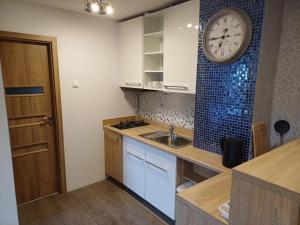 a kitchen with a clock on the wall and a sink at Ubytovanie Pod lesom in Ľubica +10 photos