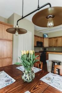a vase of yellow flowers on a wooden table at Picturesque Condo perfect for Golf, Families, Pools and Lake vacation in Bellaire +24 photos