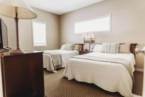 a hotel room with two beds and a flat screen tv at Picturesque Condo perfect for Golf, Families, Pools and Lake vacation in Bellaire