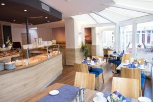 a restaurant with tables and chairs and a counter at Gästehaus Janßen in Cuxhaven