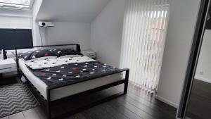 ein Schlafzimmer mit einem Bett mit einer schwarz-weißen Bettdecke in der Unterkunft 7 stars in Środa Śląska