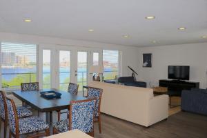 a living room with a table and chairs and a television at Southbank Hotel Jacksonville Riverwalk in Jacksonville