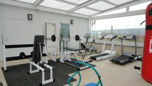 einen Fitnessraum mit Kardiogeräten und einem großen Fenster in der Unterkunft Hotel Mirador in Velilla de San Antonio
