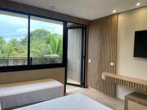 a bedroom with a large window with a view at Carpe Diem Eco Resort Olímpia in Olímpia +68 photos