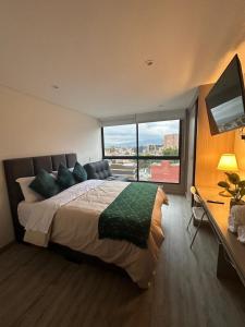 una camera da letto con un letto grande con una grande finestra di Your ideal space in Bogota a Bogotá