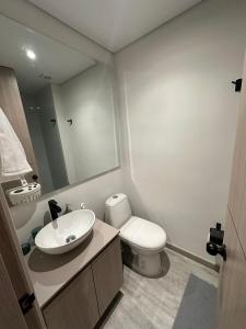 un bagno con lavandino, WC e specchio di Your ideal space in Bogota a Bogotá