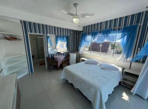 a bedroom with a bed and a table and a window at Pousada Bella Praia in Torres +37 photos