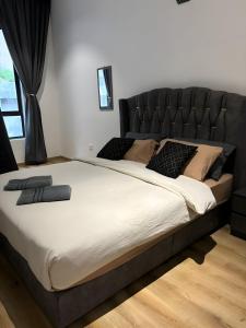 a large bed with a black headboard in a bedroom at Serene Terrace House 2-12pax &Sunrise View in Brinchang