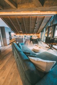 a large green couch in a room with a piano at LIVALPIN Hideaway in Garmisch-Partenkirchen