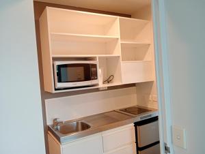 a kitchen with a microwave and a sink at Princeton 30 Symonds Street in Auckland