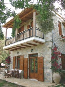 a house with a balcony on top of it at Homeberry, Traditional Stone House in Tiros in Tiros