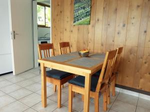 a wooden table with chairs and a bowl of fruit on it at Ferienwohnung C11 in Orselina