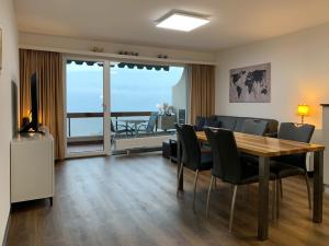 a living room with a dining room table and chairs at Ferienwohnung D27 in Orselina