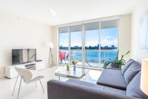 a living room with a couch and a large window at Golden Bay 406 in Miami Beach