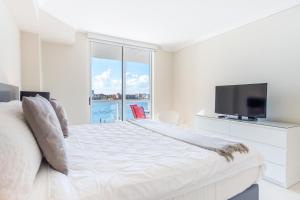 a white bedroom with a large bed and a tv at Golden Bay 406 in Miami Beach +31 photos