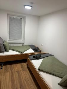 Dos camas en una habitación con ventana. en Innsbruck home, en Innsbruck