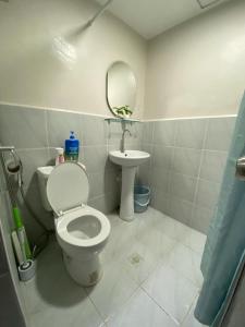 un baño con inodoro y lavabo en Comfort & Style Studio Pool view with Balcony, en Lapu Lapu City