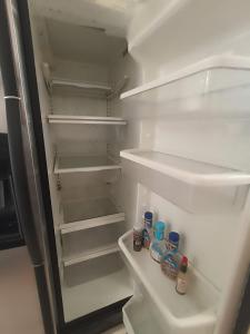 una nevera abierta con botellas de comida. en Casa indico, en Cabo San Lucas