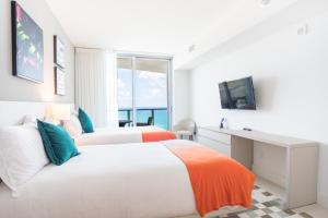 two beds in a bedroom with a desk and a window at Lyfe Beach Resort 3804 in Beverley Beach +26 photos