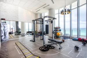 a gym with cardio equipment in a large room with windows at Lyfe Beach Resort 3804 in Beverley Beach