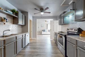 una cucina con armadi bianchi e un ventilatore a soffitto di The Green Cottage a Corpus Christi