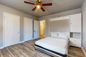 una camera con letto bianco e ventilatore a soffitto di The Green Cottage a Corpus Christi