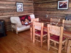 una sala da pranzo con tavolo, sedie e divano di Cabañas Walwalün a Tunuyán