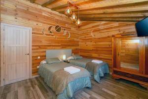 a bedroom with two beds in a log cabin at El rincón de Rosina in Sequera de Fresno