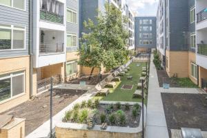 an apartment courtyard with benches and trees in a building at Trendy Riverwalk Retreat King Bed Free Parking Pool Gym in San Antonio