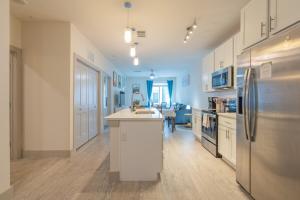 a kitchen with a sink and a refrigerator at Trendy Riverwalk Retreat King Bed Free Parking Pool Gym in San Antonio