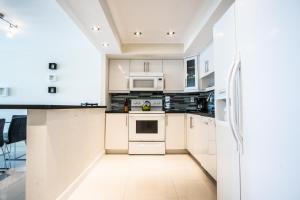a kitchen with white cabinets and white appliances at Ocean Reserve 927 in Miami Beach