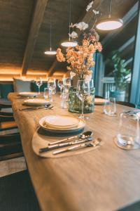 a long wooden table with plates and silverware on it at LIVALPIN Hideaway in Garmisch-Partenkirchen