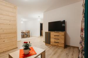 a living room with a television and a table at Zacisze z bilardem, sauną i jacuzzi in Biały Dunajec