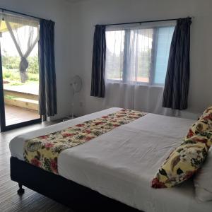 a bedroom with a bed and a window with a view at Mama MIREKA Homestay in Arorangi