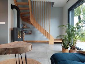 a living room with a staircase and a blue couch at Domki Miłe Chwile in Lubiatowo