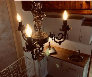 a bathroom with a chandelier with a sink and two candles at Riverside Apartment in Bitola +42 photos