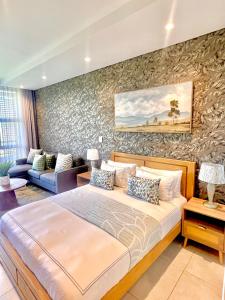 a bedroom with a bed and a stone wall at Boulevard suite 242 in Ballito