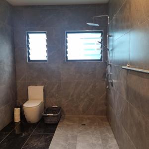 a bathroom with a toilet and a window at Mama MIREKA Homestay in Arorangi +10 photos