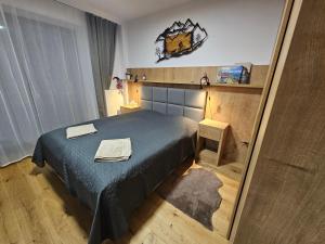 a small bedroom with a bed and a mirror at Horský apartmán s možností wellness Benecko by AlkaTravel in Benecko