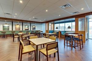 a dining room with tables and chairs and windows at Fairfield Inn & Suites by Marriott Dallas Love Field in Dallas