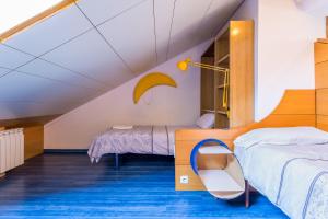 un dormitorio en el ático con 2 camas y una escalera en BaruHaus duplex piscina y parking, en Villamañán