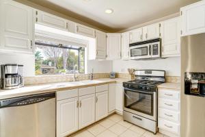 Una cocina con gabinetes blancos y una ventana. en Santa Barbara Home with Private Outdoor Pool!, en Santa Bárbara