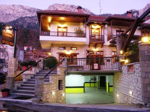 a house with stairs and a basketball court in front of it at Hotel Mpakou in Elati Trikalon
