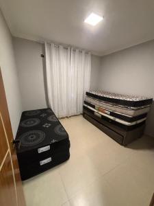 twee eenpersoonsbedden in een kamer met een raam bij Apto Vista Mar com Ar cond, Piscina, Wifi, TV e Garagem 2 vagas in São Vicente +20 foto's