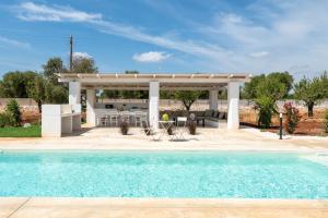 a pool with a gazebo and a house at Tenuta Buganvillea -Private pool in Ostuni