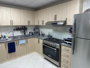 シャルジャにあるCloudsのキッチン(木製キャビネット、ステンレス製の冷蔵庫付) +22枚の写真